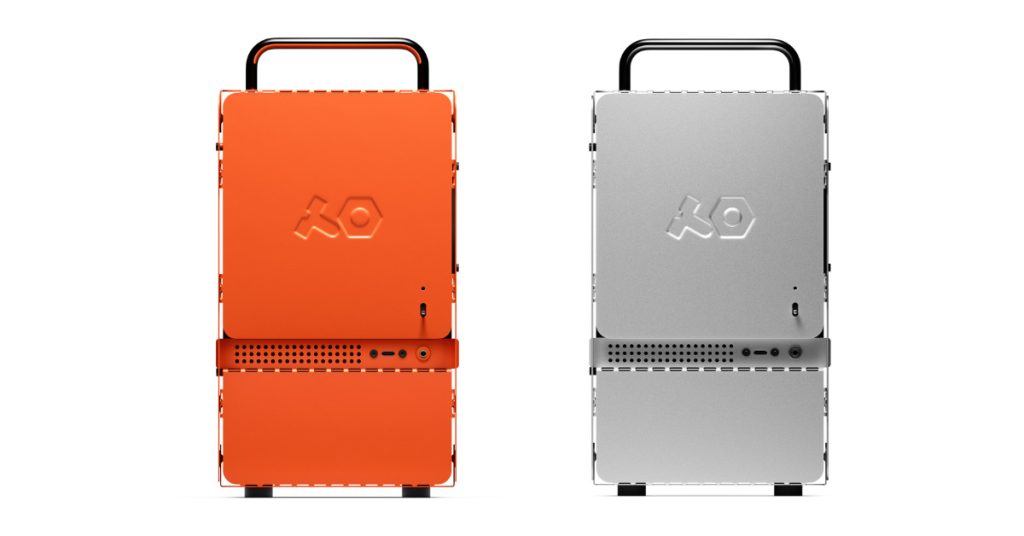 Two Teenage Engineering Computer-1 mini-ITX cases side-by-side, one in RAL 2004 orange and one in anodized aluminum, showing the industrial flat-pack design with top handles.
