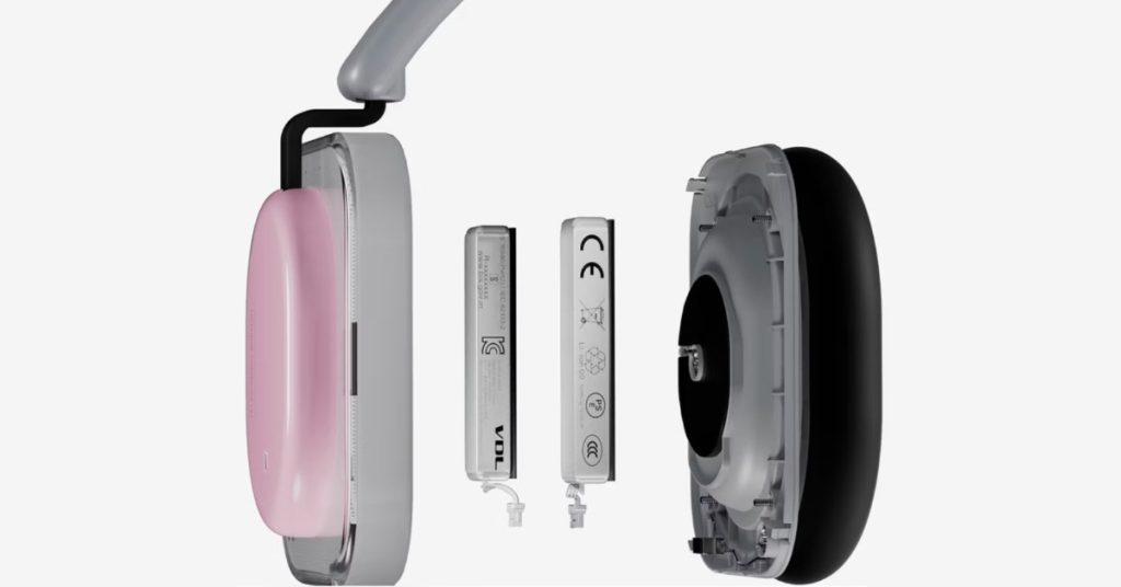 An exploded view of the Nothing Headphone (a) earcup, showing the internal battery and acoustic chamber components. The pink outer shell and thick black ear cushion are visible, highlighting the hardware engineering behind its 135-hour battery life.